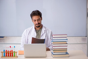 Wall Mural - Young male chemist teacher in front of whiteboard