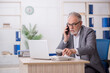 © Elnur - Old male employee working in the office