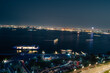 Doha, Qatar - February 23, 2024: A night view of Doha Corniche showing traditional Qatari boats, Doha Road, and the waters of the Gulf