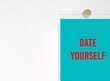 on copy space wall - stick note with message written DATE YOURSELF - taking yourself out for date, making relationship commitment and be content with being alone