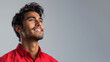 Side candid view of Indian businessman in red shirt smiling isolated