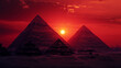 Multiple pyramids in Eqypt with red setting sun in the back. 