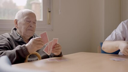 Wall Mural - Senior man sorting cards ready to play in a geriatric