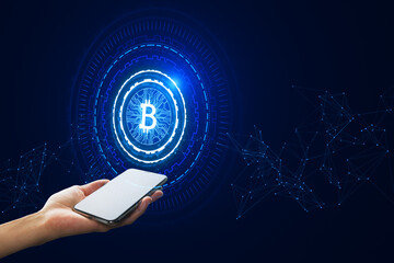 Wall Mural - Close up of female hand holding mobile phone with creative glowing round bitcoin hologram on dark background. Cryptocurrency and finance concept.