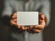 © Cheetose - Mockup with beautiful manicured hands holding a 5 inches wide by 7 inches length, blank invitation card vertically, light background.