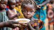 Poor young girl stands holding a bowl filled with food, looking directly at the camera