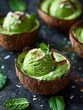 coconut shells filled with green ice cream, sprinkled with mint leaves and edible seeds on top