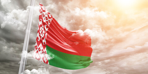 Belarus national flag cloth fabric waving on beautiful cloudy Background.