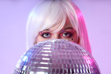 Poster - Beautiful young woman with disco ball on color background, closeup