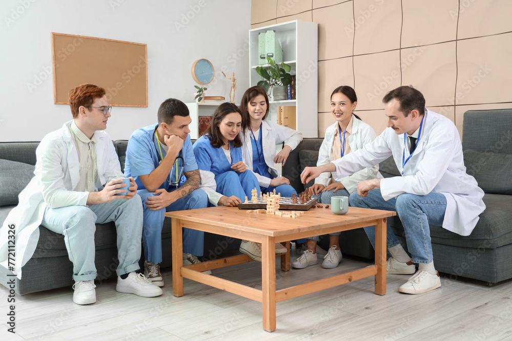 Team of doctors playing chess in hospital lounge