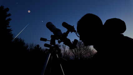 Wall Mural - amateur astronomer looking at the evening skies, observing planets, stars, moon and other celestial 