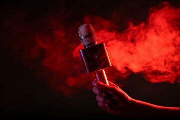 Wall Mural - Woman with modern microphone and red smoke on dark background