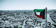 colorful Kuwait flag waving in the wind over the black and white cityscape drone view photo