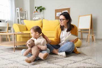 Canvas Print - Sad little girl with toy bear at psychologist's office