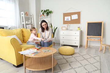 Canvas Print - Female psychologist showing pictures to little girl in office