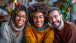 Portrait of three diverse friends smiling and looking at camera while sitting together in coffee shop