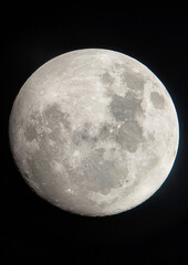 a high-resolution picture of the bright full moon shines in the dark sky, revealing its bumpy surfac