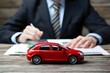 © Nida - Toy car in front of businessman calculates car loan