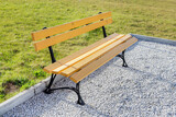 Fototapeta Kwiaty - Beautiful yellow wooden bench in the garden. Optimistic symbol of joy and hope.