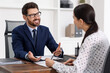 © New Africa - Woman signing document in lawyer's office, selective focus