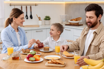 Poster - Happy family having breakfast at table in kitchen