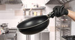 Frying pan in hand of cook. Professional kitchen utensils. Frying pan in restaurant kitchen. Equipment for cooking. Frying pan with detachable handle. Non-stick dinner cooking equipment