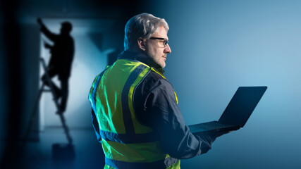 Poster - man foreman. engineer with laptop. gray-haired worker in yellow vest. engineer monitors work employe