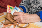 Fototapeta  - A pensioner in Switzerland counts money, Swiss francs - problems of older people, financial concept