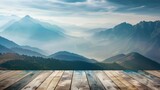 Fototapeta  - Misty mountains with morning light on wood deck - A serene dawn breaks over mist-covered mountains, seen from a weathered wooden deck viewpoint
