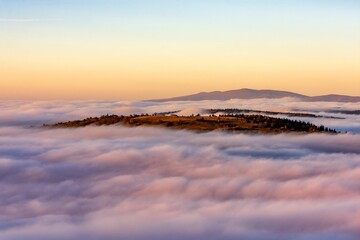 Wall Mural - Scenic view of mountains hidden in a sea of clouds at sunset. Kremnica Mountains, Slovakia.