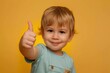 © Anna - a toddler giving a thumbs up on color background