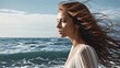   A woman with long hair stands before a tranquil body of water Sun rays caress her face as her locks billow in the wind