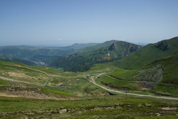 Wall Mural - Scenic landscape of a winding green valley surrounded by majestic mountains