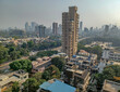 Mumbai, India - 10 March 2024: Rural to urban development of mumbai in sion west with trees and skyscrapers in background