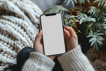 A woman is holding a cell phone with a white background