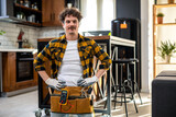 Fototapeta Panele - Portrait of Latino handyman. Standing in the kitchen with all the equipment.