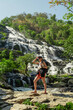 A woman is hiking at the huge water fall in Chiangmai Thailand.