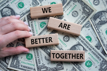 Wall Mural - We are better together symbol. Wooden blocks with words We are better together. Beautiful dollar background. Businessman hand. We are better together concept. Copy space.