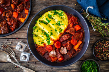 Wall Mural - Irish stew for St. Patrick's Day - roast beef in beer with potato puree  served on wooden table
