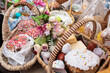 a basket with traditional pastries, Easter Kulich cake and colored eggs, in front of other baskets with Easter food. Many baskets are displayed on the table for the consecration and blessing 