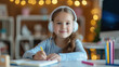 A young smiling girl in her bedroom does homework with headphones