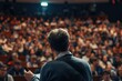 © Konstiantyn Zap - A man stands confidently before a large crowd, passionately delivering a lecture. The audience listens intently, eager to absorb his words of wisdom