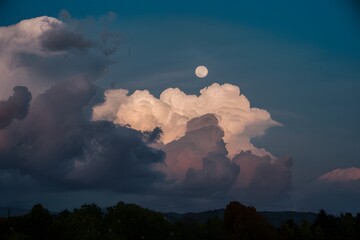 Wall Mural - Moonlight filters through billowing clouds in a mesmerizing scene