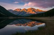 Sunset bathes lake and mountains in golden hues for wallpaper