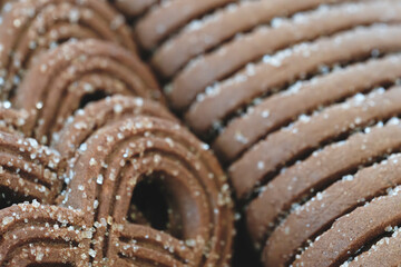 Poster - A close up of a bunch of chocolate cookies with sugar sprinkled on top. The cookies are stacked on top of each other, creating a visually appealing and delicious display. Concept of warmth and comfort
