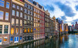 Amsterdam canal Singel with typical dutch houses and houseboats during morning blue hour, Holland, Netherlands 
