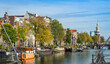 Channel in Amsterdam Netherlands houses river Amstel landmark old European city autumn landscape.