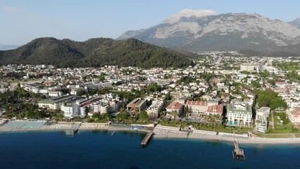 Wall Mural - Picturesque summer aerial view of coastal area of Kemer and marina with moored yachts on Mediterranean coast on background of Taurus Mountain range, Antalya province. Famous resort on Turkish Riviera