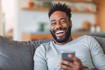 Wall Mural - African man playing with smartphone while laughing