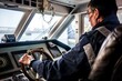 ships captain navigating from the bridge, hands on wheel